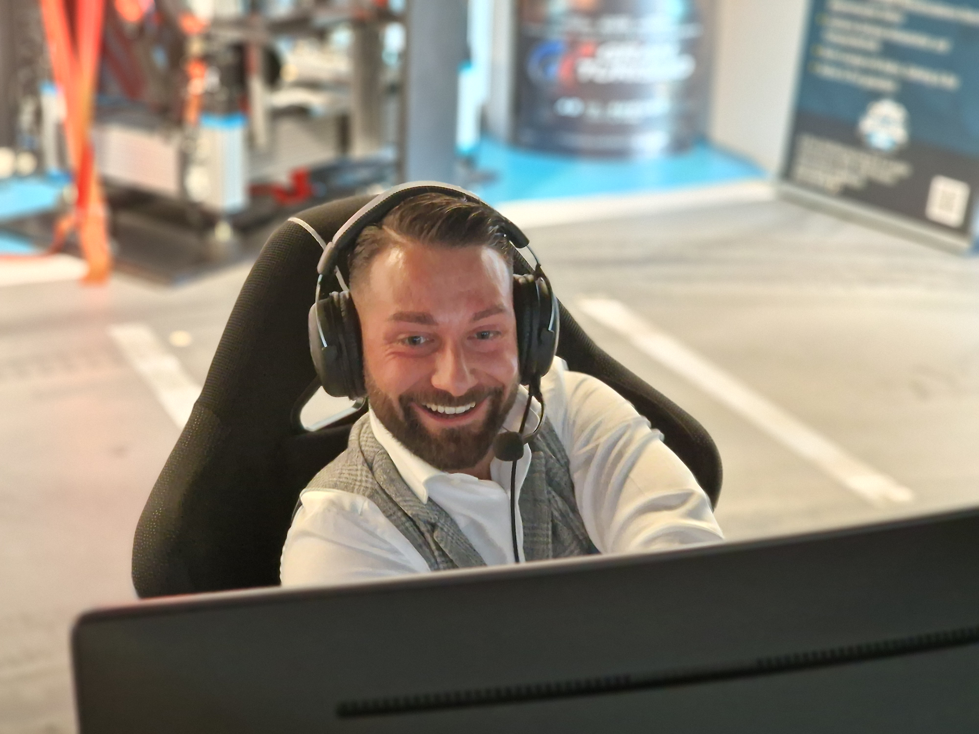 Fahrer im APlus SimRacing Simulator mit Headset